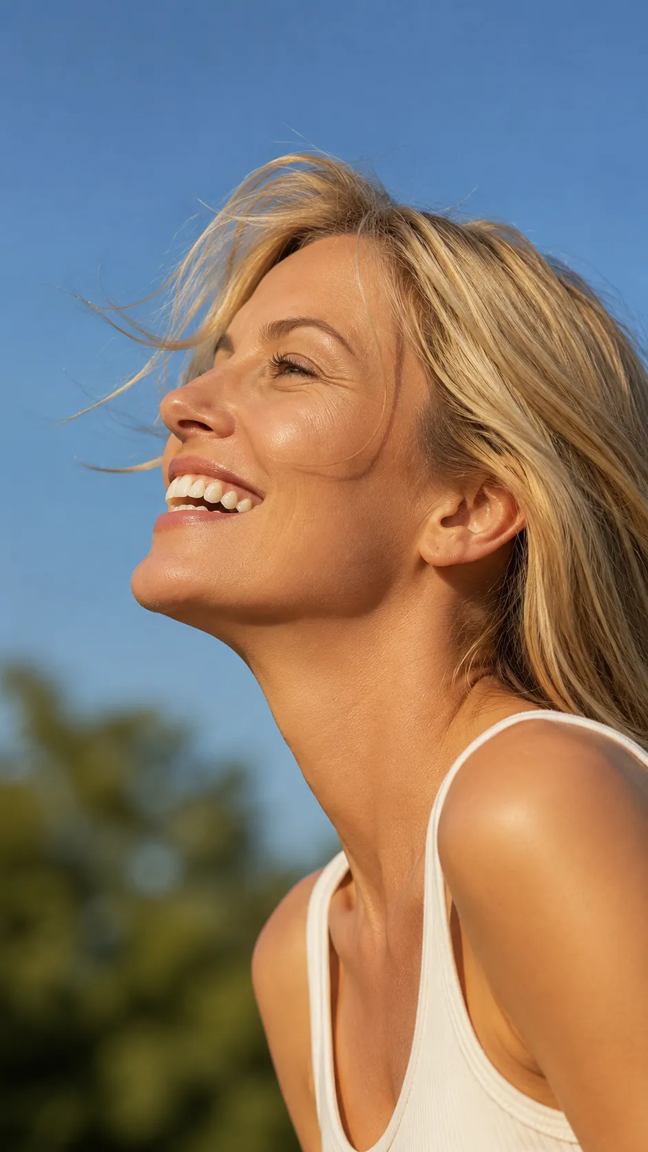 Mujer sonriendo al aire libre con vistas abiertas hacia la zona boscosa